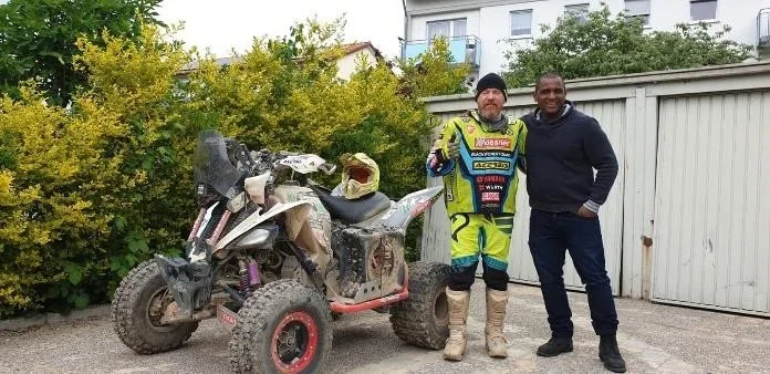 Juan Carlos Carignani in rally gear, standing with Flédéric Payet.